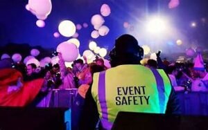 A security guard with this back facing the camera posing as event security.
