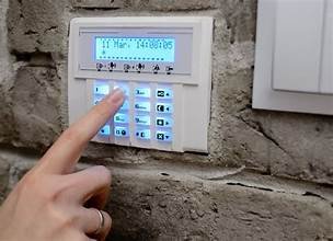 A person typing in on a pin lock on a door.