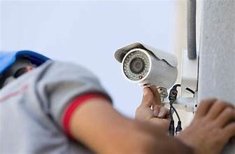 A security guard setting up a CCTV camera.